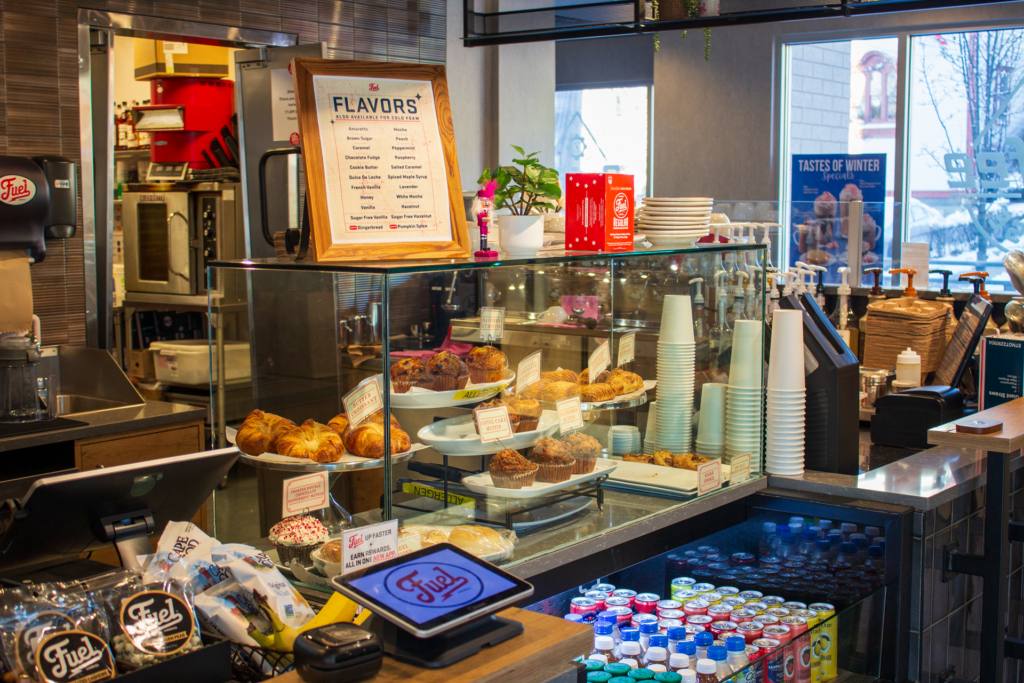 A display case containing several bakery items at a Fuel America cafe, including muffins, croissants, and more.